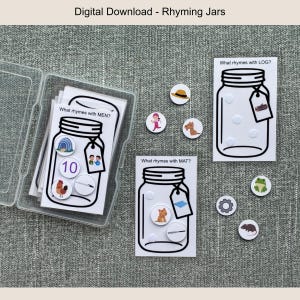 Op de afbeelding: Een digitale download van rijmende potten. De afbeelding toont een doorzichtige plastic container met kaarten met potcontouren en de tekst "What rhymes with MEN?" en "What rhymes with MAT?". Kleine cirkelvormige afbeeldingen van objecten zijn inbegrepen.