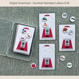 May include: A set of alphabet flashcards featuring gumball machine designs. Each card displays a letter and corresponding images. The cards are red and white, with a clear plastic case. The text "Digital Download - Gumball Alphabet Letters A-M" is at the top.