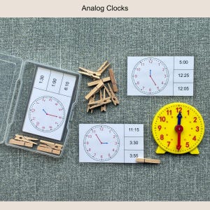 May include: Educational analog clock set with a clear plastic case, wooden clothespins, and clock faces displaying different times. A yellow clock with red and blue hands is also included. The text "Analog Clocks" is at the top.