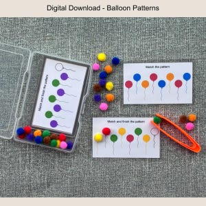 Può includere: Gioco educativo con pompon colorati, carte e una pinzetta arancione. Le carte presentano motivi a palloncino con il testo "Match and finish the pattern" e "Match the pattern". Una scatola di plastica trasparente contiene alcuni pompon e carte.