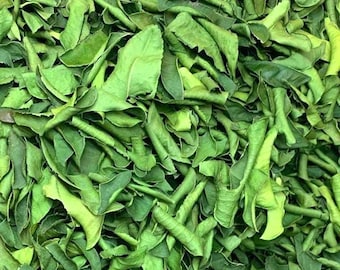 May include: Close-up of a pile of dried green kaffir lime leaves. The leaves are various shades of green, with some appearing lighter and others darker. The leaves are textured and have a slightly curled appearance, suggesting they have been dried.