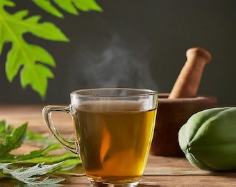 May include: A clear glass mug filled with steaming amber liquid, likely tea, sits on a wooden surface. Green leaves and a green papaya are in the background. A wooden mortar and pestle are also visible.