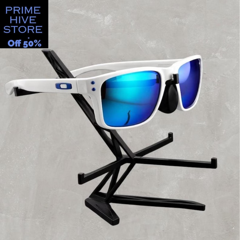 Peut inclure: Des lunettes de soleil blanches avec des verres bleus miroir sont pr&eacute;sent&eacute;es sur un pr&eacute;sentoir en m&eacute;tal noir. Les lunettes ont une monture blanche avec des accents bleus. Le pr&eacute;sentoir a un design g&eacute;om&eacute;trique. Le texte "PRIME HIVE STORE" et "Off 50%" est dans le coin sup&eacute;rieur gauche.