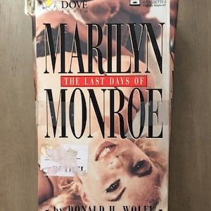 May include: A vintage audio cassette case for "Marilyn: The Last Days of Monroe" by Donald H. Wolfe. The case features a photo of Marilyn Monroe and the Dove Audio logo. The case contains 6 cassettes.