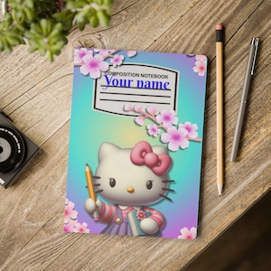 May include: A composition notebook with a gradient blue and purple cover featuring a white cat character with a pink bow, holding a pencil and a small book. The cover is decorated with pink cherry blossoms and includes a label area with the text "COMPOSITION NOTEBOOK Your name" printed in black and blue.