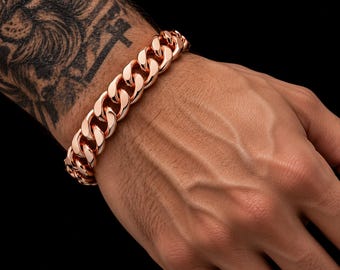 Op de afbeelding: Een gepolijste roségoudkleurige gourmetarmband met dikke, in elkaar grijpende ovale schakels. De armband heeft een hoogglanzende metalen afwerking en een veilig sluitingsmechanisme, met een klassiek ontwerp van zware schakels.