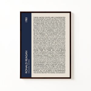 K&ouml;nnte beinhalten: Gerahmter Druck mit Text aus Ronald Reagans Antrittsrede von 1981. Das Kunstwerk hat einen cremefarbenen Hintergrund mit schwarzem Text. Ein vertikaler marineblauer Streifen auf der linken Seite enth&auml;lt den Text "Ronald Reagan" und "1981".