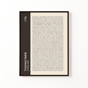 May include: A framed print of text from Thomas Paine's "Common Sense" from 1776. The design has a dark brown vertical bar with the year and author's name. The text is in a serif font on a cream background.