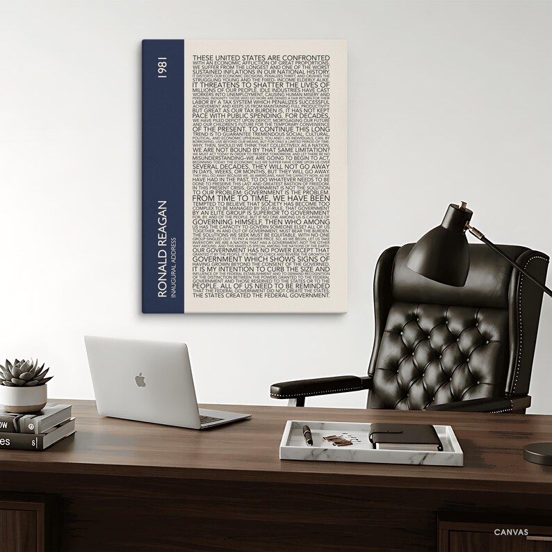 K&ouml;nnte beinhalten: Leinwanddruck mit dem Text von Ronald Reagans Antrittsrede von 1981. Der Druck hat einen cremefarbenen Hintergrund mit schwarzem Text und einen marineblauen vertikalen Streifen auf der linken Seite mit Name und Jahr.