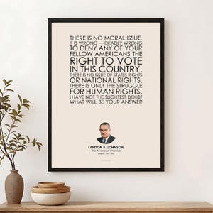 May include: A framed wall art print featuring a cream background with black text quoting Lyndon B. Johnson's 1965 speech on voting rights. Below the text is a small portrait of Lyndon B. Johnson, his name, the title The American Promise, and the date.