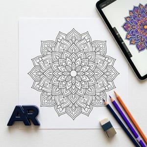 Puede incluir: Un diseño de mandala en blanco y negro detallado sobre papel blanco, con lápices de colores, un borrador y una tableta que muestra una versión coloreada. El mandala es un patrón simétrico, ideal para colorear o meditar.