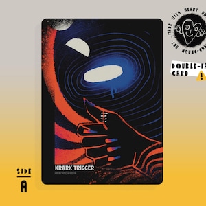 May include: Double-sided card with a cosmic design. The card features a hand with a red nail, pointing towards a bright blue and white oval shape. The text "KRARK TRIGGER" and "SIDE A" are visible.