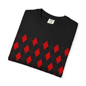 May include: Black t-shirt with a repeating pattern of red and dark gray diamond shapes across the lower portion. The shirt has a crew neck and a small tag on the collar.