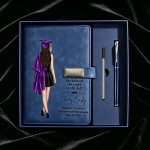 Puede incluir: Un set de regalo con cuaderno azul y bolígrafo. La portada del cuaderno muestra el gráfico de una persona graduada con toga y birrete morados, junto al texto "She believed she could so she did!", "Sherry Crosby", "Bachelor of Science", "University of Pennsylvania" y "Class of 2025".