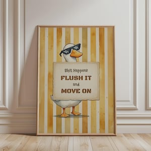 Pode incluir: Uma impressão de parede vertical emoldurada apresentando um pato branco usando óculos de sol pretos pixelados. O pato segura uma placa retangular com o texto: Shit Happens FLUSH IT and MOVE ON. O fundo consiste em listras verticais amarelas e brancas.