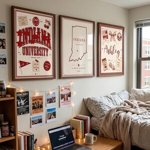 May include: Three framed wall art prints featuring a cream background with dark red accents. The left print displays Indiana University text and graphics. The center print shows an Indiana state map outline. The right print features the name Ashley.