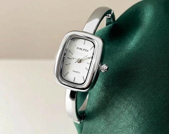 Women's quartz wristwatch with square silver case and cuff bangle bracelet