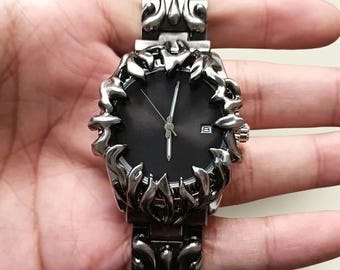 Men's quartz wristwatch with dramatic flame design case, black dial and ornate alloy bracelet
