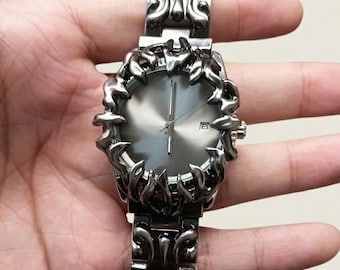 Montre-bracelet à quartz pour homme avec boîtier en forme de flammes spectaculaires, cadran rouge et bracelet en alliage orné