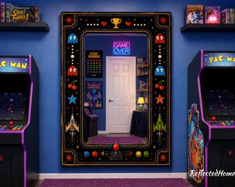 以下が含まれることがあります： レトロアーケードゲームをテーマにした、黒いフレームの大きな鏡。鏡には、カラフルなパックマンのキャラクター、星、ジョイスティックのデザインが施されています。「GAME OVER」の文字がネオンで表示されています。2台のアーケードゲーム機が鏡の両側にあります。