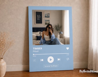 以下が含まれることがあります： 音楽プレーヤーのインターフェースに似せてデザインされた、水色のウォールアート。 このアートワークは、人物の写真、Pitbullの曲名「TIMBER」、そして「forever & always」というテキストが特徴です。