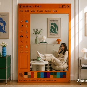 Könnte beinhalten: Ein orangefarbener Spiegel, der wie eine Computerschnittstelle für ein Malprogramm gestaltet ist. Der Spiegel verfügt über eine Menüleiste, Werkzeugsymbole und Farbfelder. Der Raum umfasst gerahmte Kunst, einen weißen Schrank und eine Person, die ein Telefon benutzt.