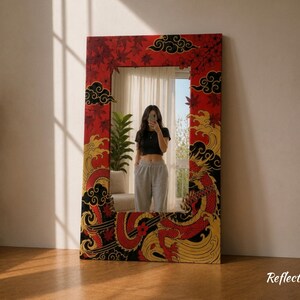 May include: A large rectangular mirror with a red frame featuring a Japanese-inspired design. The frame is adorned with red maple leaves, black clouds, and a golden dragon. The mirror reflects a room with a person.