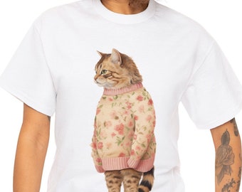 May include: White t-shirt with a watercolour illustration of a cat in a floral sweater. The cat has brown and tan fur and green eyes. The sweater is light pink with red and pink flowers. The cat has a striped tail.