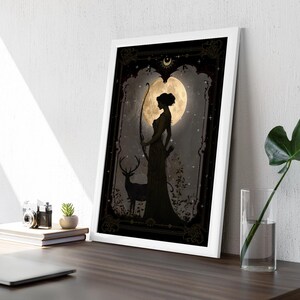 Puede incluir: Una ilustraci&oacute;n en blanco y negro de una mujer con un arco y una flecha de pie frente a una luna llena. Un ciervo se para a su lado. El fondo es un bosque oscuro con estrellas.