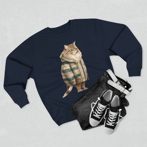 May include: A navy blue sweatshirt with a graphic of a cat wearing a striped sweater. The cat is looking to the right and has a fluffy tail.