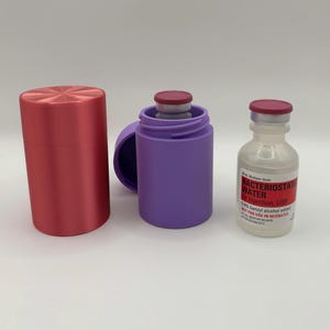 May include: A cylindrical red protective case, a purple cylindrical case with a matching lid, and a clear glass vial of Bacteriostatic Water for Injection, USP, 30 ml, with a maroon cap and a label containing medical information.