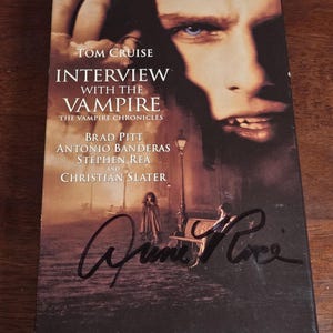 Puede incluir: Una cinta VHS de la película "Entrevista con el vampiro" con Tom Cruise, Brad Pitt y Antonio Banderas. La portada presenta a Tom Cruise y el texto "Drink From Me And Live Forever".