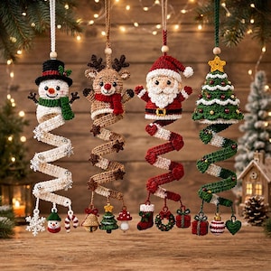 Puede incluir: Cuatro adornos colgantes de ganchillo con un muñeco de nieve, un reno, Papá Noel y un árbol de Navidad. Cada figura está unida a una larga cola de ganchillo en espiral decorada con pequeños amuletos festivos como copos de nieve y regalos.