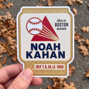 May include: A rectangular sticker with a gold border featuring a white baseball with red stitching, a red triangle, and the text Live in BOSTON MASS, NOAH KAHAN, and JULY 7, 8, 10, 11-2026. The design includes a grid pattern at the top and bottom.