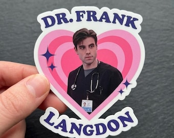 Peut inclure: Un autocollant avec un portrait d'un homme en tenue médicale, encadré par un cœur rose. Le texte "DR. FRANK" et "LANGDON" en bleu, avec des étoiles bleues, ornent l'autocollant.