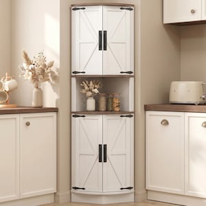 May include: A white corner cabinet with two sets of doors, each with black hardware and a farmhouse style. The cabinet has a dark brown top and bottom, and a shelf in the middle. The cabinet is in a kitchen.