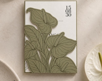 Puede incluir: Una tarjeta de invitación rectangular blanca con una superposición troquelada de color verde oliva de flores y hojas de anturio. La tarjeta muestra los números 15, 08, 30 en una fuente negra vertical en la parte superior derecha y la palabra MILIES debajo.
