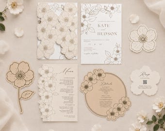 Puede incluir: Un conjunto de papelería de boda en papel crema y blanco con ilustraciones florales de líneas negras. Incluye una tarjeta floral cortada con láser, una invitación rectangular para Kate y Hudson, un menú, una tarjeta circular y una tarjeta RSVP.