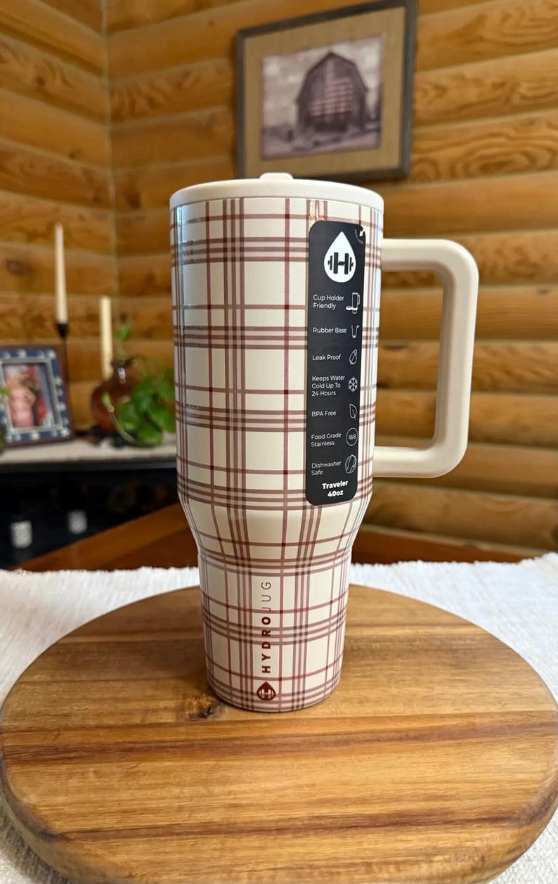 Pode incluir: Uma caneca de viagem HydroJug xadrez branca e marrom com uma al&ccedil;a grande. A caneca tem uma base de borracha e &eacute; &agrave; prova de vazamentos. Mant&eacute;m a &aacute;gua fria por at&eacute; 24 horas e n&atilde;o cont&eacute;m BPA. A caneca pode ser lavada na m&aacute;quina de lavar lou&ccedil;a e cont&eacute;m cerca de 1,14 litros.