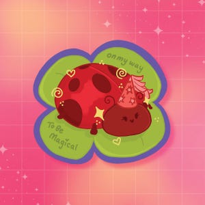 May include: A sticker featuring a red ladybug with black spots and a smaller red creature wearing a pink party hat, both resting on a green four-leaf clover. The text reads "on my way" and "To be Magical" with small yellow hearts and stars.