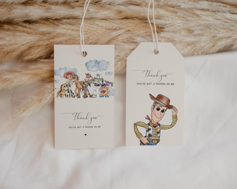 May include: Two cream gift tags with string. One tag features a cartoon of Woody, the cowboy, tipping his hat. The other tag has a cartoon of characters from Toy Story. Both tags have the text "Thank you, You've got a friend in me."