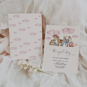 May include: Baby shower invitation with a watercolor design. The invitation features a pink cloud pattern on the back and a themed illustration on the front with the text "It's a girl story". Includes event details.