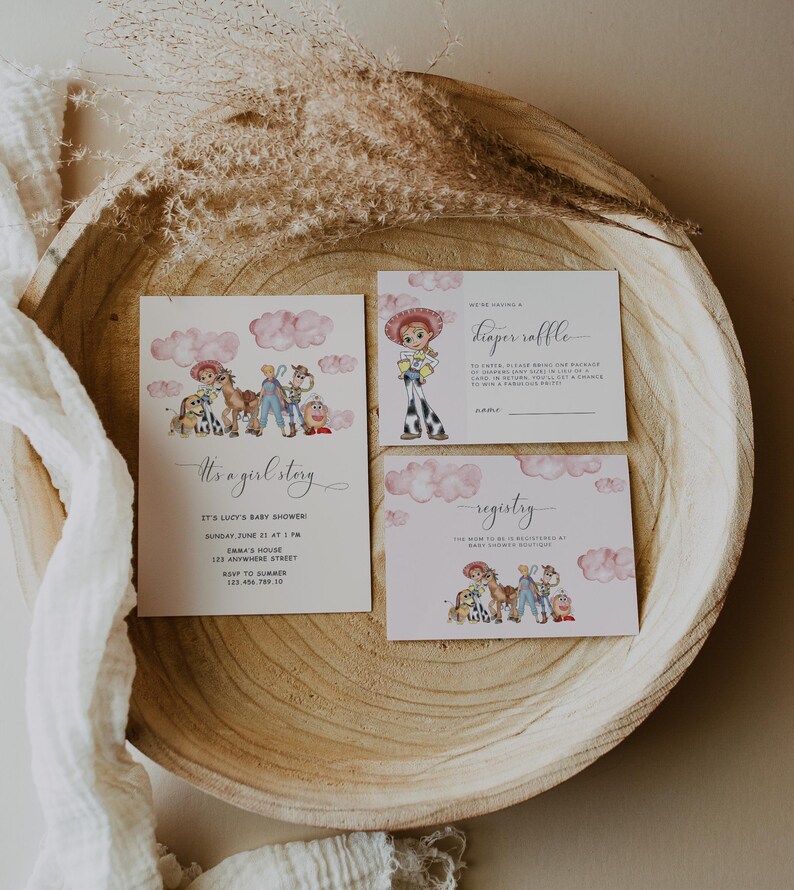 May include: A set of baby shower invitations with a watercolor illustration of a cowgirl and other characters. The invitations include the text "It's a girl story" and details for the event. The design is set on a wooden tray.