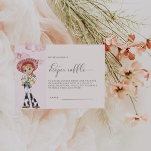 May include: A baby shower invitation card with a cartoon cowgirl illustration. The card reads "We're having a diaper raffle" and includes details about the raffle. Soft pink and white background with floral accents.
