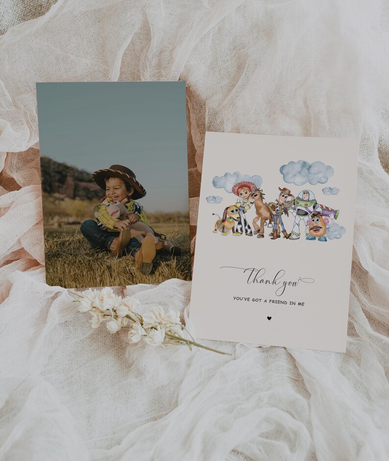 May include: Two cards on a white surface. One card features a photo of a child in a cowboy hat. The other card has a watercolour illustration of Toy Story characters with the words "Thank you" and "You've got a friend in me."