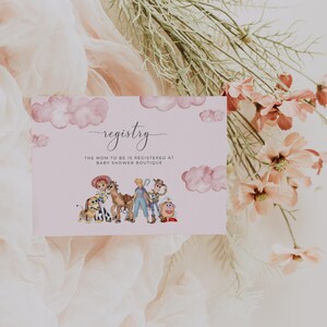 May include: A baby shower registry card with a pink background and watercolor illustrations of Toy Story characters. The word "registry" is written in cursive, with the text "The mom to be is registered at Baby Shower Boutique" below.
