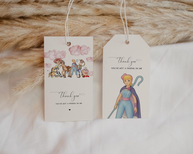 May include: Two cream-colored gift tags with string. One tag features a watercolor illustration of characters from a movie, with the text "Thank you, You've got a friend in me." The other tag shows a character with a staff and the same text.