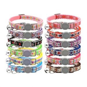 Puede incluir: Una colección de coloridos collares para gatos con estampados florales y pequeñas campanas. Los collares presentan una variedad de colores, incluyendo rosa, morado, negro, verde, amarillo y azul. Cada collar tiene una hebilla de plástico gris.