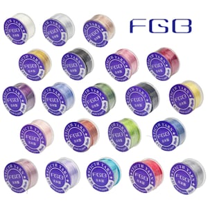May include: A collection of nineteen individual spools of FGB brand Sticth Yarn in various colors. Each spool features a purple circular label with white text reading Sticth Yarn, FGB, 50yds, and Japanese characters, arranged in a grid.