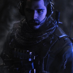 May include: A person wearing tactical gear, including a dark vest with visible ammunition pouches, a patterned scarf around the neck, and a headset with a microphone. The lighting is dim with a strong blue tint, highlighting the facial features.